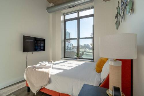 1 dormitorio con cama y ventana grande en McCormick Place with city view 2br/2ba - optional Parking & Gym, en Chicago