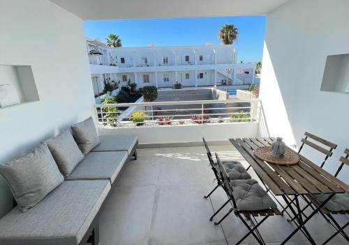 - un balcon avec un canapé, une table et des chaises dans l'établissement Las Caracolas Deluxe Apartment Nº5, à Puerto del Carmen