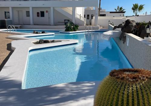 - une piscine d'eau bleue dans un bâtiment dans l'établissement Las Caracolas Deluxe Apartment Nº5, à Puerto del Carmen