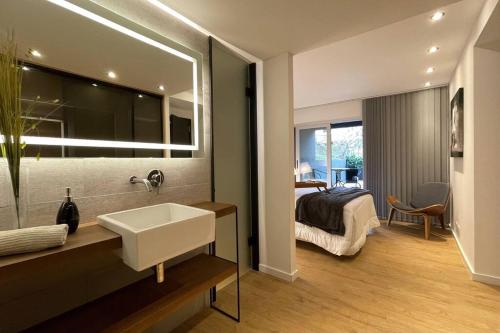 a bathroom with a sink and a bedroom with a bed at Apartamento deluxe en Pocitos_Life Veintiseis Apartments in Montevideo