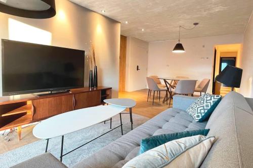 sala de estar con sofá y TV de pantalla plana en Apartamento deluxe en Pocitos_Life Veintiseis Apartments, en Montevideo