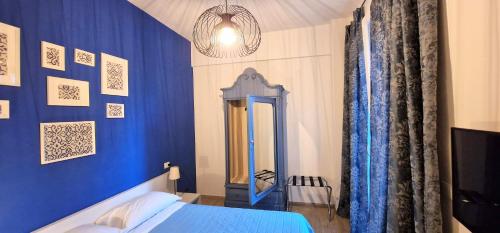 ein blaues Schlafzimmer mit einem Bett und einem Spiegel in der Unterkunft Central City Rooms m09 Apartment in Bologna