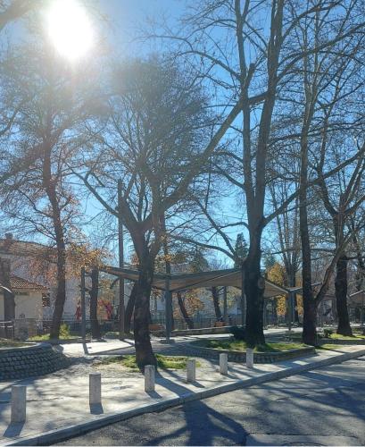 a park with trees and benches and the sun at FBM Anagenessis - Ευ Ζην in Edessa