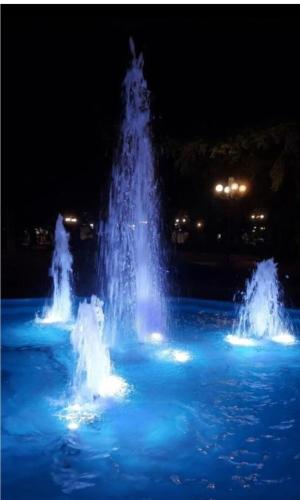 a fountain with blue lights in the water at night at FBM Anagenessis - Ευ Ζην in Edessa