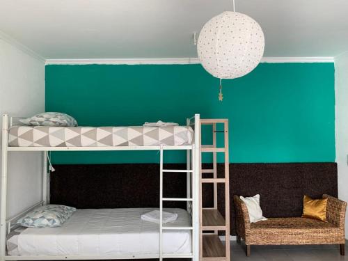 um quarto com 2 beliches e uma parede verde em Sublime Sun & Van - By Meco Stays em Alfarim