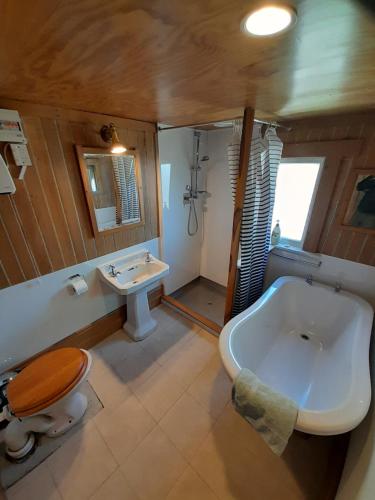 a bathroom with a tub and a toilet and a sink at The Capitain's Cabin in Bluff