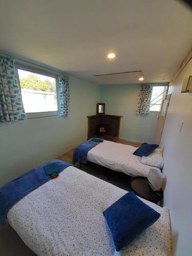 a bedroom with two beds and two windows at The Capitain's Cabin in Bluff