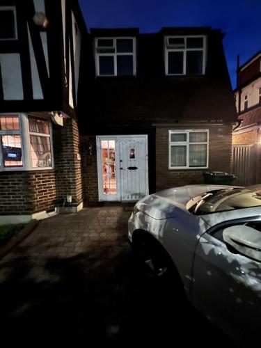 a car parked in front of a house with a white door at 5- bed gem in Barnet short let luxury awaits in Barnet