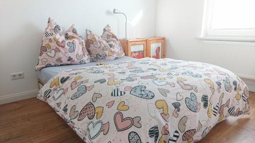 a bedroom with a bed with a comforter with hearts at Bungalow in Messenähe in Hannover