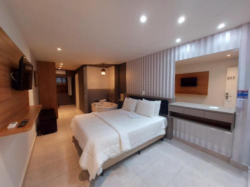 a hotel room with a bed and a bathroom at Hotel Vila Suíça 1818 in Nova Friburgo