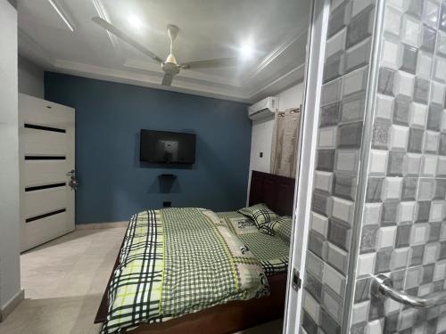 Schlafzimmer mit einem Bett und einem Deckenventilator in der Unterkunft T-Roys Apartments in Accra