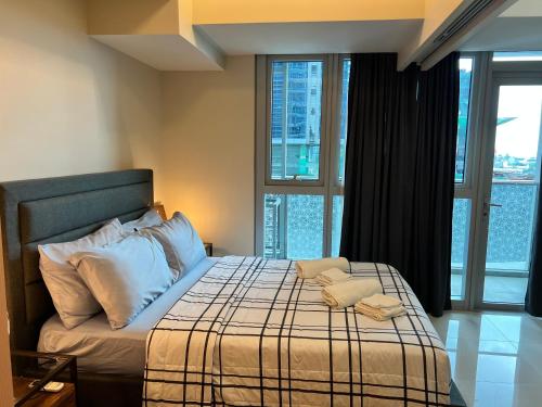 a bedroom with a bed with a large window at Uptown Parksuites II in Manila