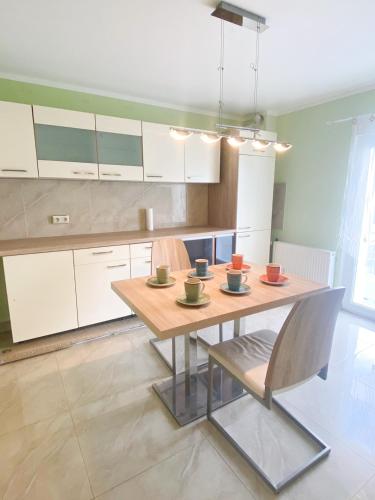 eine Küche mit einem Holztisch mit vier Tassen darauf in der Unterkunft Extrem ruhiges Apartment- Leipzig Ost (A14) in Leipzig