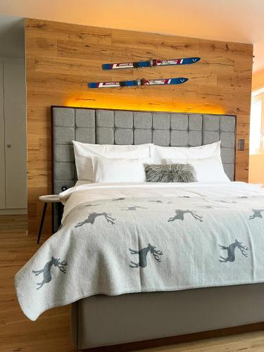 Schlafzimmer mit einem Bett mit grauem Kopfteil in der Unterkunft Wunderstay Alpine 401 Chic Studio with Mountain view in Engelberg