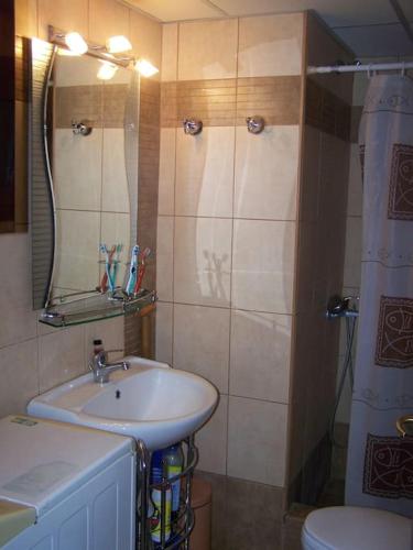 a bathroom with a sink and a toilet and a mirror at Paralia Ofriniou Sea view apartment in Orfánion