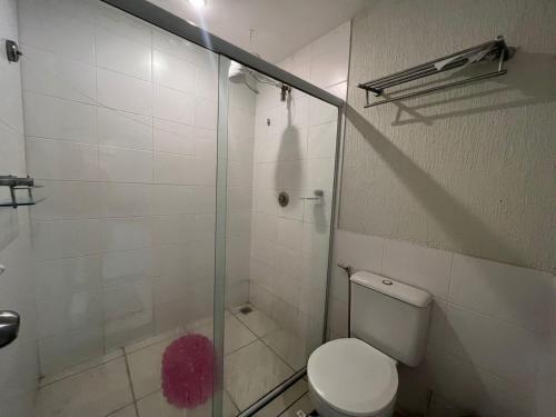 a bathroom with a toilet and a glass shower at Apartamento/Flat - Condominio Village - Aldeia das Águas Park Resort. in Barra do Piraí
