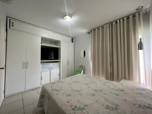 a bedroom with a bed and a tv and a window at Apartamento/Flat - Condominio Village - Aldeia das Águas Park Resort. in Barra do Piraí