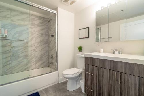 y baño con aseo, lavabo y ducha. en McCormick Place city with view 2br-2ba with Optional parking that sleeps up to 6, en Chicago