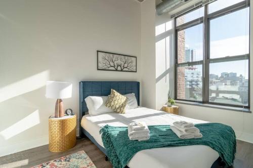 1 dormitorio con 1 cama grande y toallas. en McCormick Place city with view 2br-2ba with Optional parking that sleeps up to 6, en Chicago
