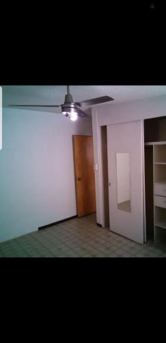 ein leeres Zimmer mit einem Deckenventilator und einem Schrank in der Unterkunft Casa en renta in Mexiko-Stadt