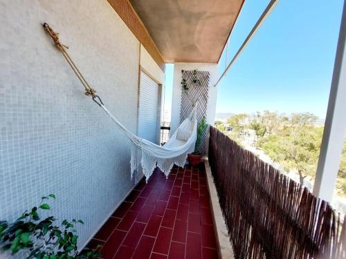 a porch with a hammock on the side of a house at Charming Avenue Apartment in Faro