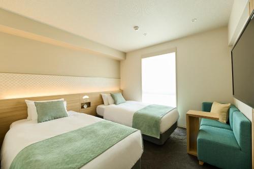 ein Hotelzimmer mit 2 Betten und einem Sofa in der Unterkunft RIHGA Place Kyoto Shijo Karasuma in Kyoto