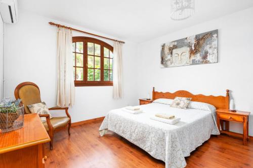 a bedroom with a bed and a table and a window at Villa Tamyan by Villa Plus in Son Parc