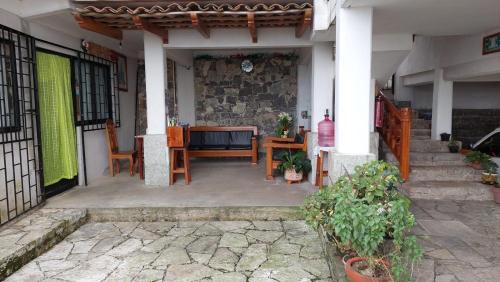 een veranda van een huis met een tafel en stoelen bij Posada El Volador in Cuetzalán del Progreso