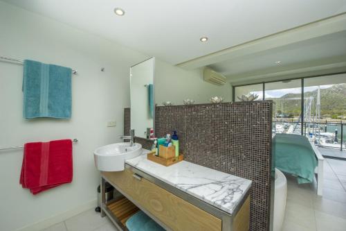 a bathroom with a sink and a mirror at Blue on Blue Apartment 327 in Nelly Bay