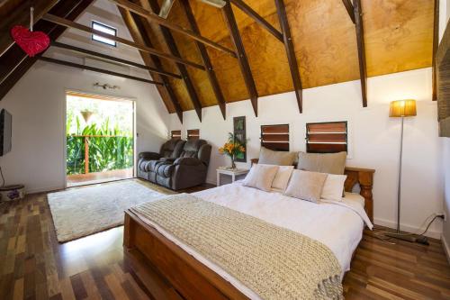 a bedroom with a large bed and a living room at Serene Place in Nelly Bay