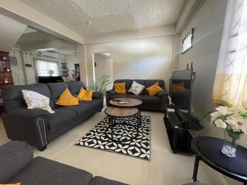uma sala de estar com um sofá e uma mesa em Mango Vert House em Arima