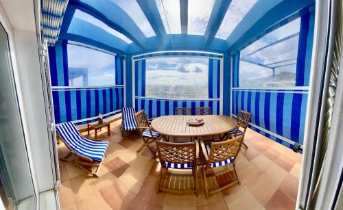 a table and chairs in a room with blue ceilings at Apartamento Pueblo Dorado in Mojácar