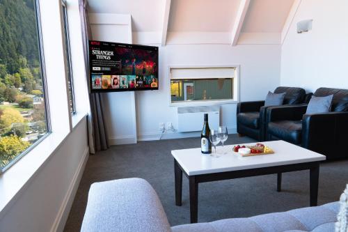 a living room with a couch a table and a tv at Turner Heights Townhouses in Queenstown