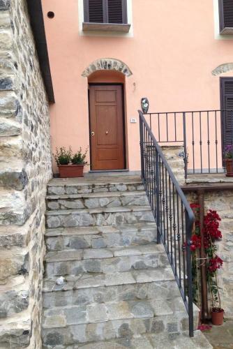 a staircase leading to a house with a brown door at Appartamenti Chiarina in Dolcedo