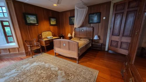 Sala de estar con cama y mesa con alfombra en Oceania House Hotel en Bantam Village