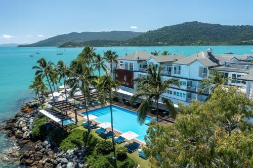 Airlie Beach的住宿－Coral Sea Resort，享有带游泳池的度假村的空中景致