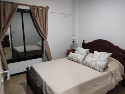 a bedroom with a bed with a large window at Dpto temporal Azhares Juan Bautista ALBERDI 187 Octavo piso B in San Salvador de Jujuy