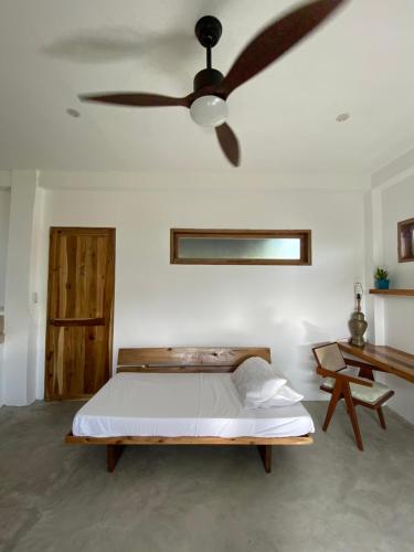 a bedroom with a bed and a ceiling fan at Secret Spot Siargao in General Luna