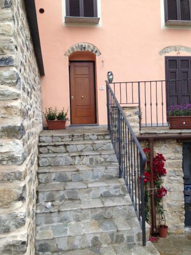 a staircase leading up to a pink house with a door at Appartamenti Chiarina in Dolcedo