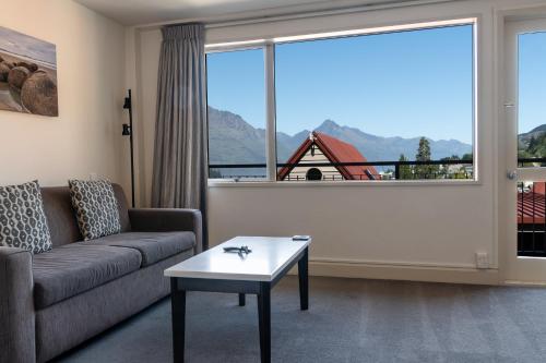 a living room with a couch and a large window at Turner Heights Townhouses in Queenstown