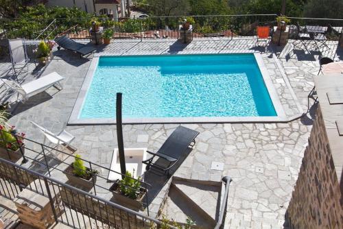 a large swimming pool with chairs at Appartamenti Chiarina in Dolcedo