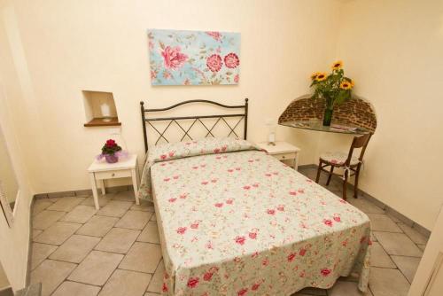 a bedroom with a bed and a table with flowers at Appartamenti Chiarina in Dolcedo
