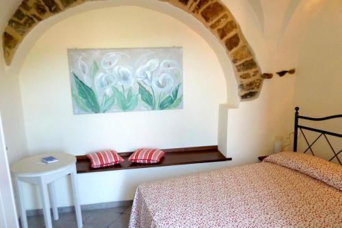 a bedroom with a bed and a painting on the wall at Appartamenti Chiarina in Dolcedo