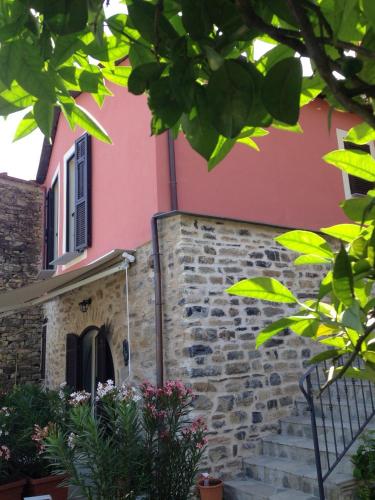 a pink house with stairs in front of it at Appartamenti Chiarina in Dolcedo