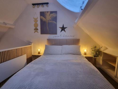 ein Schlafzimmer mit einem großen weißen Bett mit zwei Leuchten in der Unterkunft Cosy Moat House Cottage #3 in Pembroke