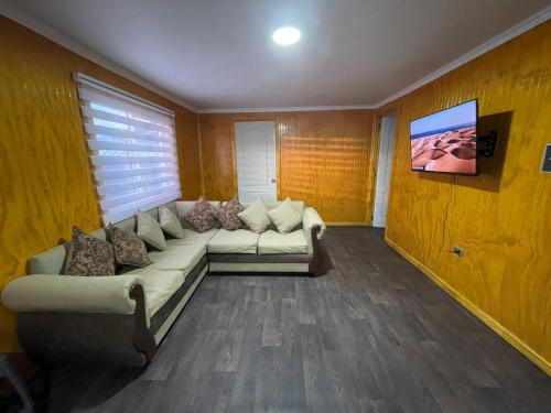 sala de estar con sofá y TV en Casa en Puerto Natales en Puerto Natales
