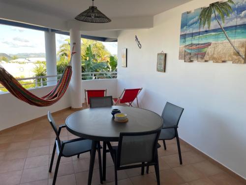 - une salle à manger avec une table et des chaises dans l'établissement T3 Spacieux aux 3 ILETS Terrasse Vue Mer, à Les Trois-Îlets