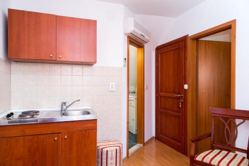 una cocina con armarios de madera y fregadero en Apartments Lepur, en Dubrovnik