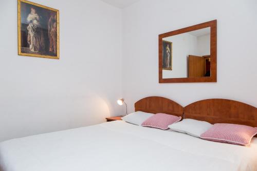1 dormitorio con cama y espejo en la pared en Apartments Lepur, en Dubrovnik