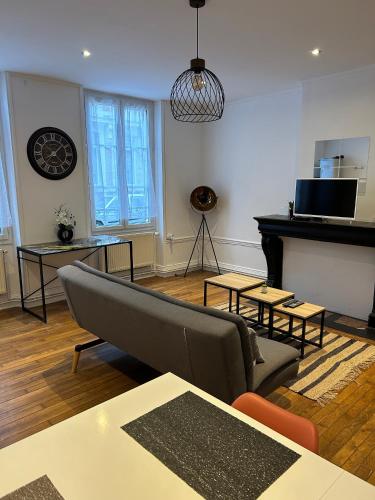 ein Wohnzimmer mit Sofa und Klavier in der Unterkunft Le voltaire 1 chez Adrien in Saint-Quentin